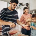 a man and two children are in the kitchen